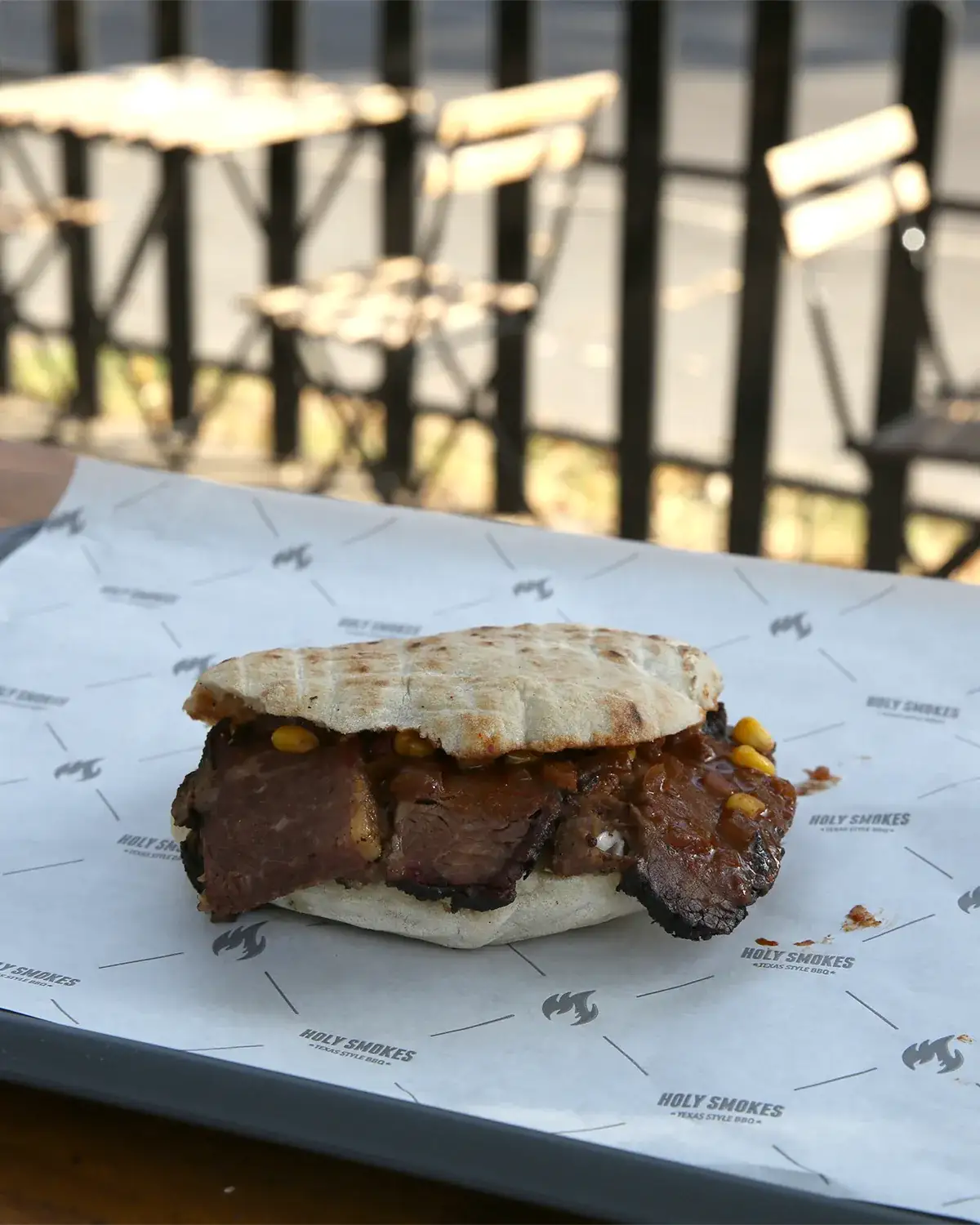 Sendvič brisket u somunu na stolu ispred restorana Holy Smokes