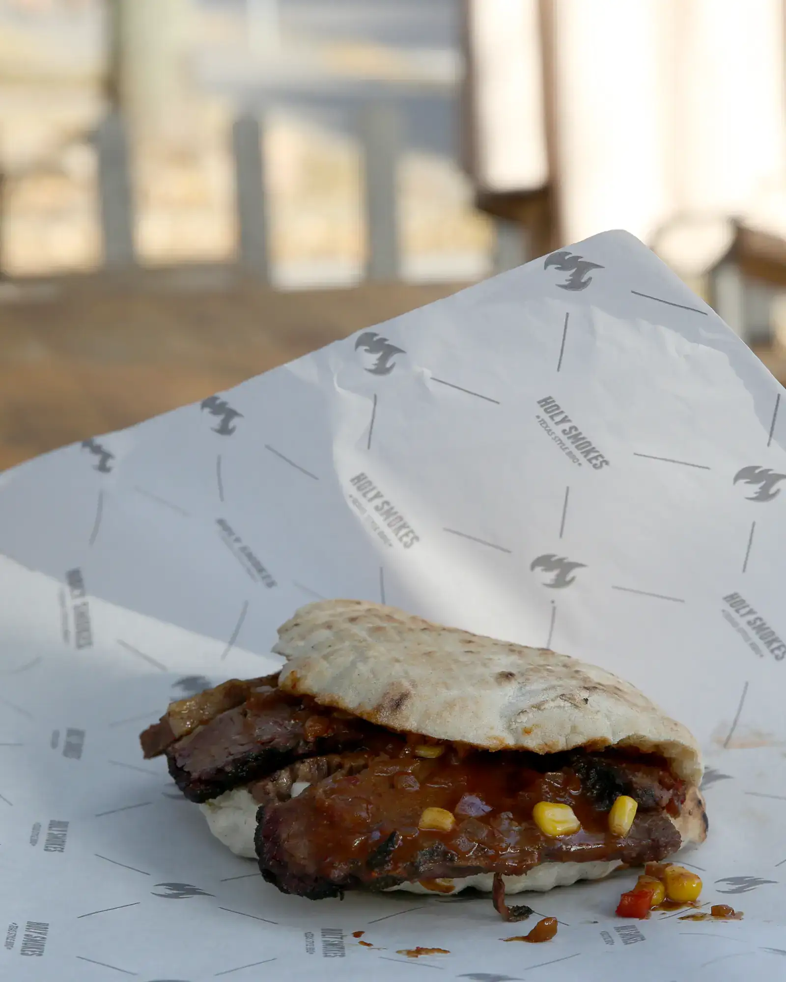 Brisket somun sendvič sa BBQ sosom na terasi restorana Holy Smokes