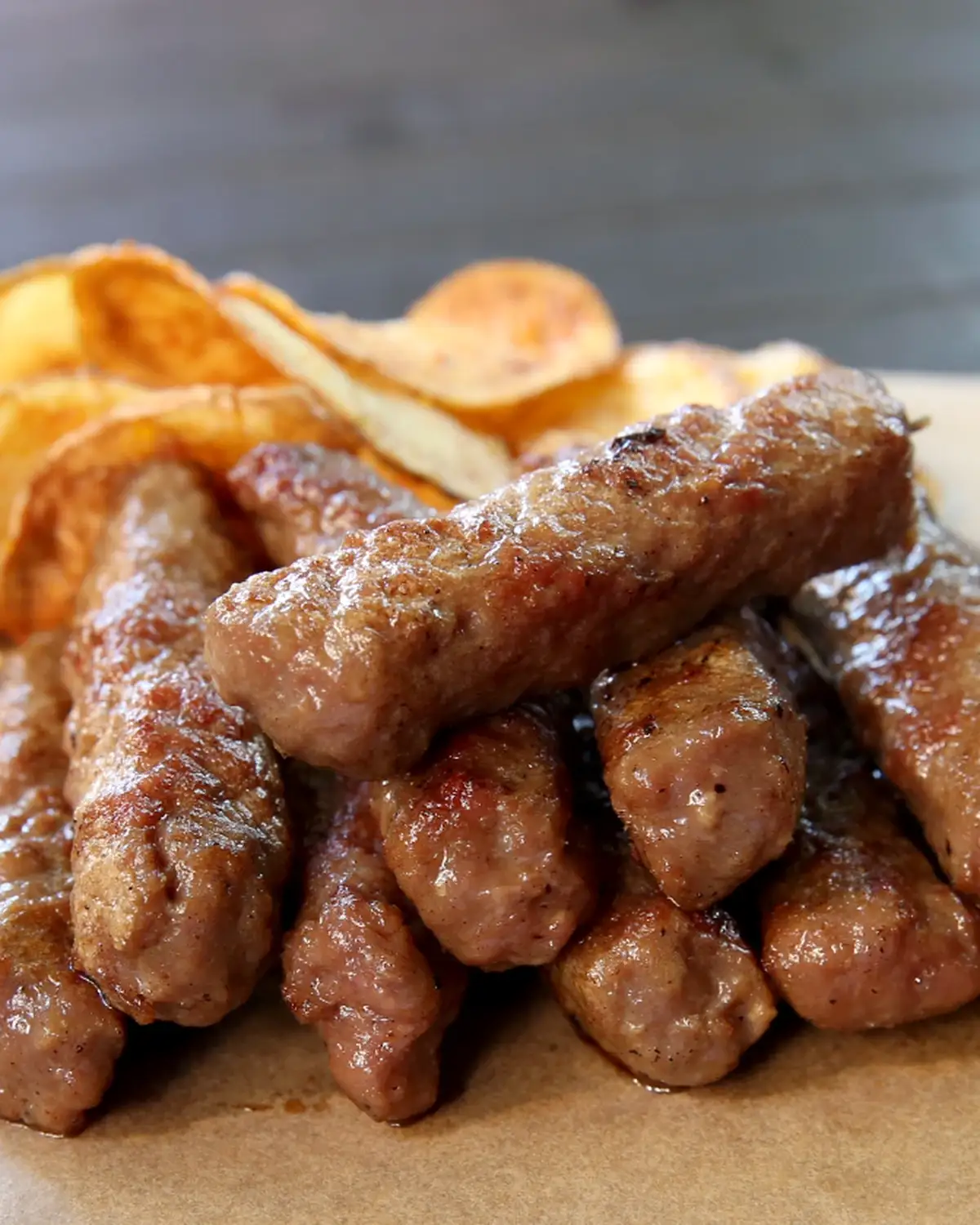 Sočni ćevapi sa roštilja naslagani ispred domaćeg čipsa, Stara pivnica Zemun