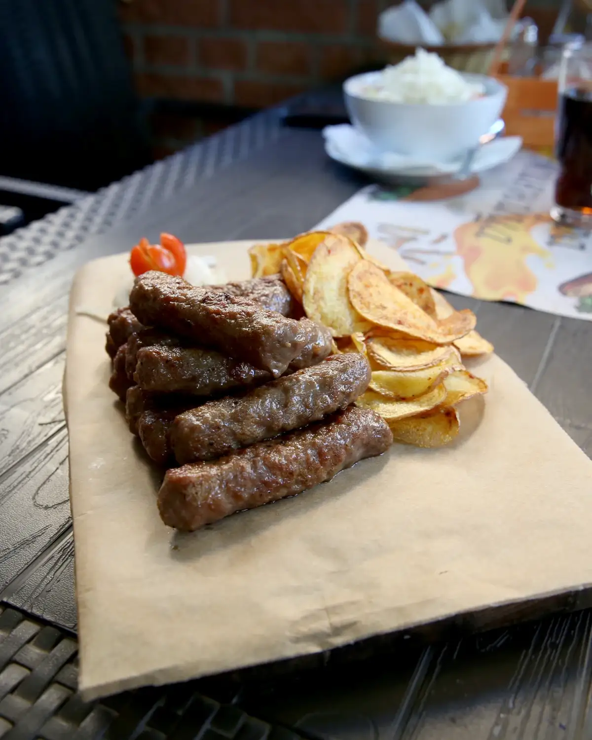 Ćevapi sa čipsom od krompira na stolu u restoranu Stara pivnica u Zemunu