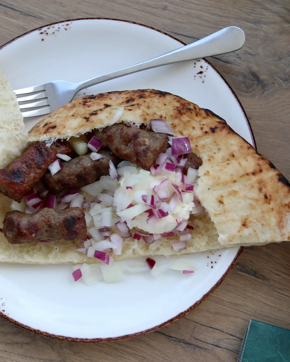 Juneći ćevapi sa kajmakom i lukom na tanjiru, restoran Walter u Zemunu