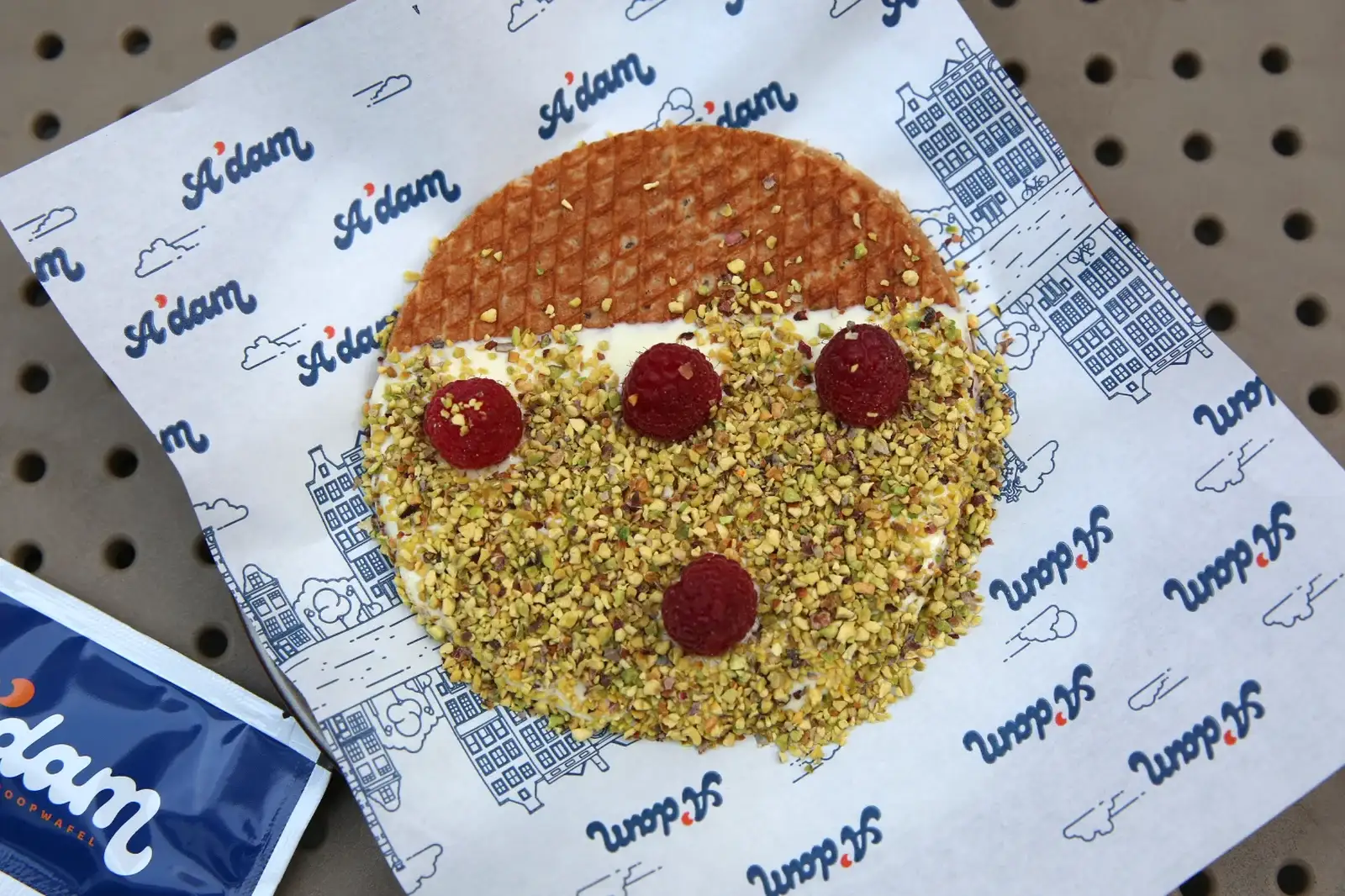 Stroopwafel sa malinom i pistaćima odozgo na A'dam papiru za pakovanje, Beograd