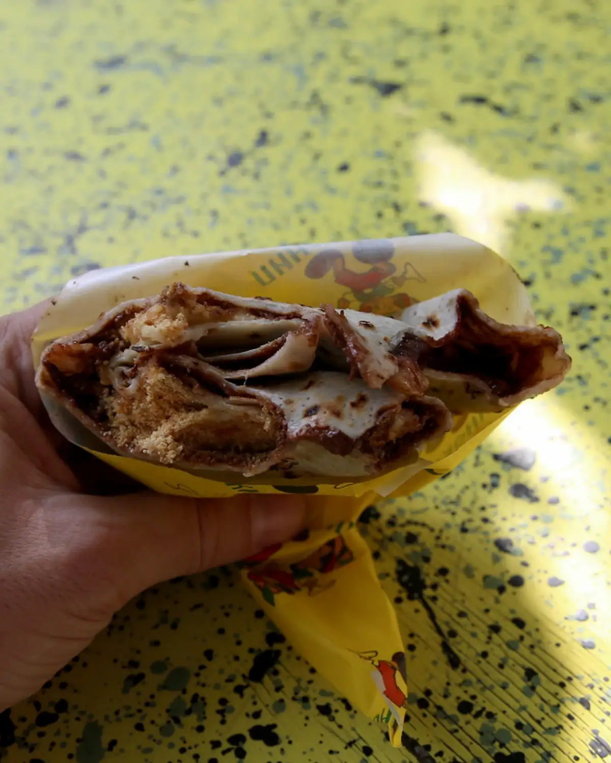 Ugriz palačinke sa nutelom, plazma keksom i bananom u ruci