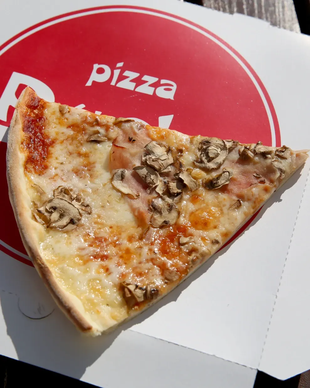 Parče pice sa šunkom i pečurkama na kutiji Bucko pizza
