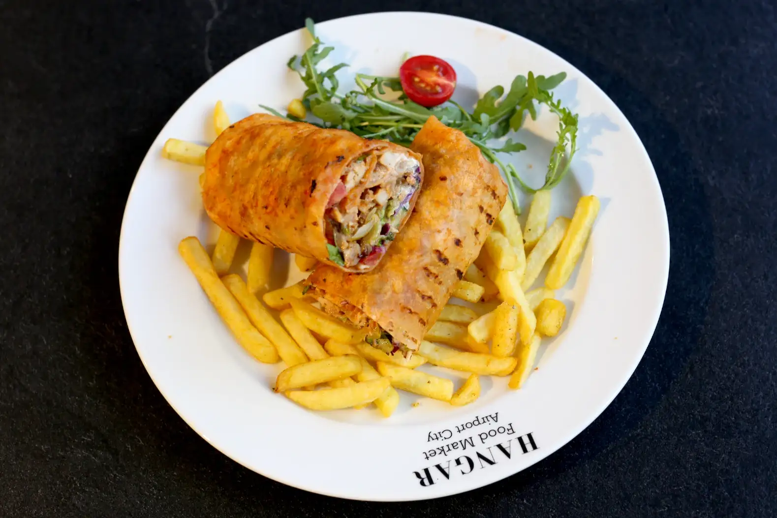Pileća shwarma u tortilji sa grila, presečena na pola, uz pomfrit, rukolu i čeri paradajz, Mama Sara, Airport City, Beograd