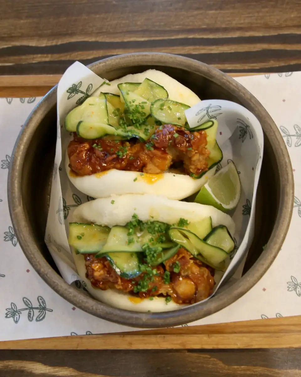 Pileći gua bao presečen napola, punjen hrskavom piletinom i krastavcem
