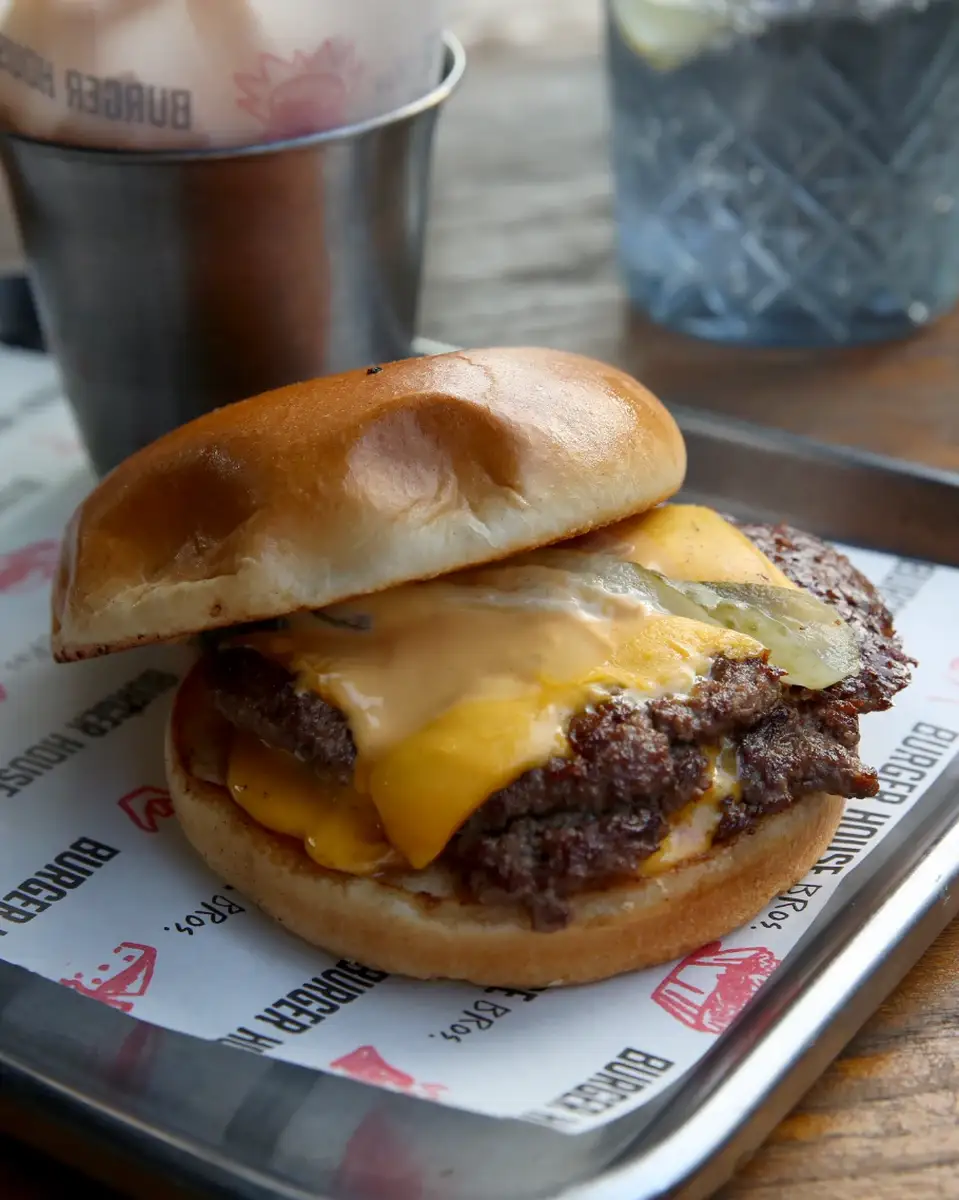 Otvoren Super Smash Triple burger sa slojevima mesa, čedara i sosa, Burger House Bros